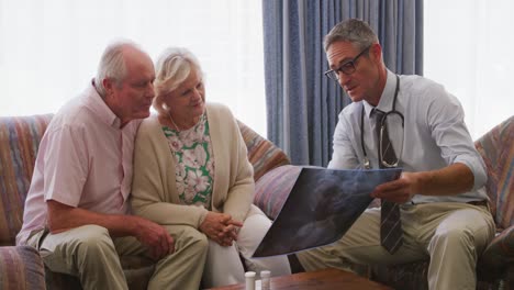 Senior-couple-talking-with-a-doctor-in-retirement-house