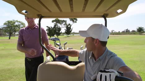 Caucasian-male-golfers-into-a-golf-buggy-