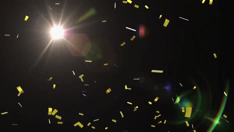 Animation-of-golden-confetti-falling-with-glowing-yellow-spotlight-moving-around-on-black-background