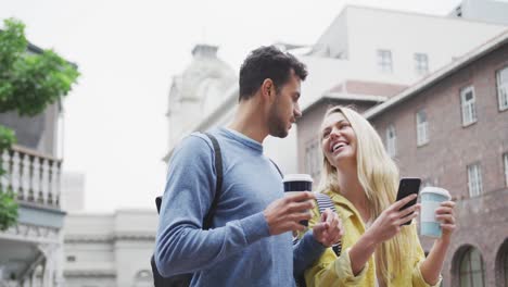 Side-view-of-Caucasian-couple-on-the-go-holding-a-takeaway-coffee-
