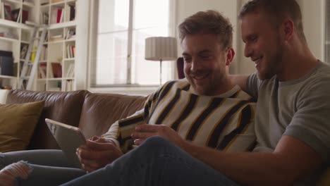 Caucasian-male-couple-in-social-distancing-in-their-sofa-at-home