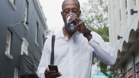 Afroamerikanischer-Mann,-Der-Einen-Kaffee-Trinkt-Und-Sein-Telefon-Benutzt