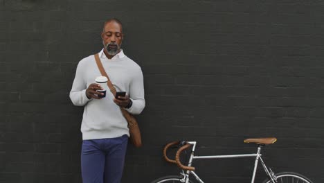 Afroamerikanischer-Mann,-Der-Einen-Kaffee-Trinkt-Und-Sein-Telefon-Benutzt