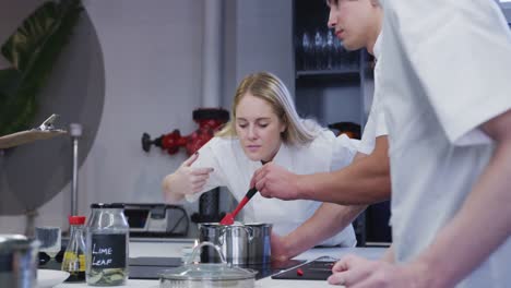 Caucasian-female-chef-wearing-chefs-whites-in-a-restaurant-kitchen-preparing-food