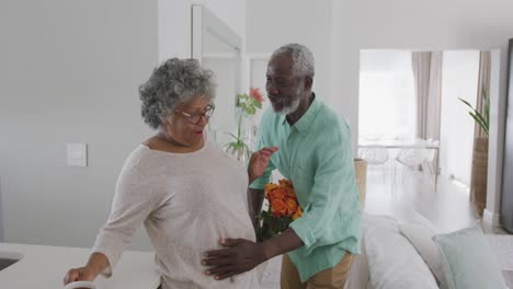 A-senior-African-American-man-offering-flowers-to-his-wife