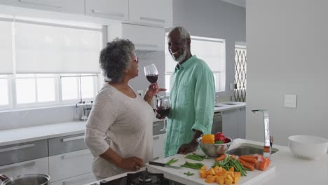 A-senior-African-american-couple-enjoying-a-glass-of-wine-in-social-distancing