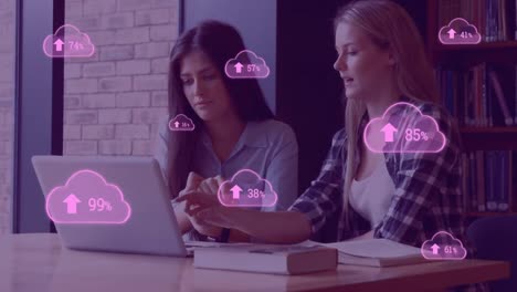 Animation-of-pink-clouds-with-percent-going-to-one-hundred-over-two-female-using-laptop-computer