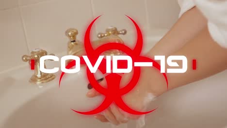 Animation-Des-Wortes-„Covid-19“,-Geschrieben-über-Einem-Gesundheitsgefährdungsschild,-Mit-Einer-Frau,-Die-Sich-Im-Badezimmer-Die-Hände-Wäscht