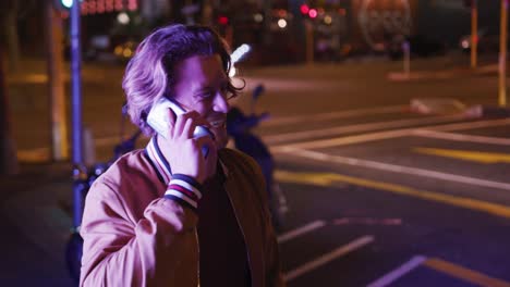 Caucasian-male-smiling-and-talking-on-the-phone-in-the-evening-