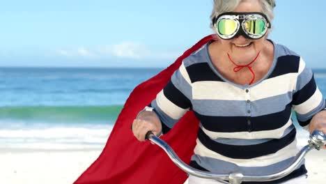 Senior-Caucasian-woman-seaside-wearing-a-red-cape