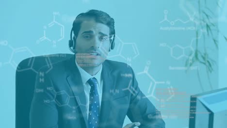 Animation-of-Caucasian-man-wearing-headset-and-using-computer-over-chemical-elements