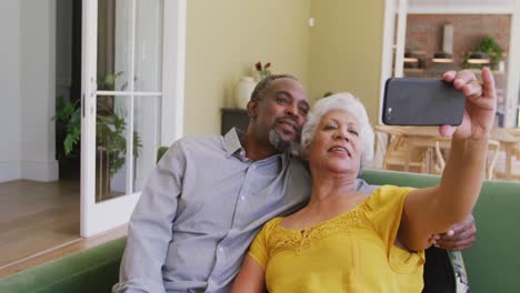 Senior-African-American-husband-and-mixed-race-wife-spending-time-and-taking-photo-at-home