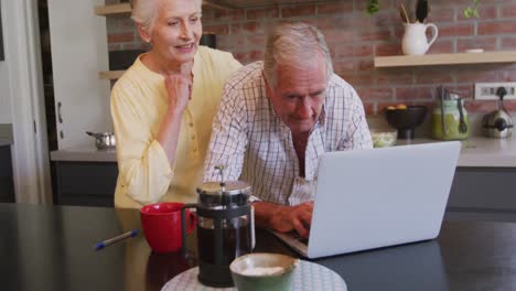 Älteres-Kaukasisches-Paar,-Das-Zu-Hause-Glücklich-Zusammen-An-Einem-Laptop-Arbeitet