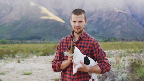 -Caucasian-man-looking-at-camera-with-his-dog-in-his-arms-