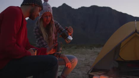 Caucasian-couple-camping-in-nature-by-night-