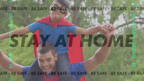 Animation-of-words-Be-Safe-Stay-At-Home-flashing-Over-caucasian-man-playing-outside-with-his-son-