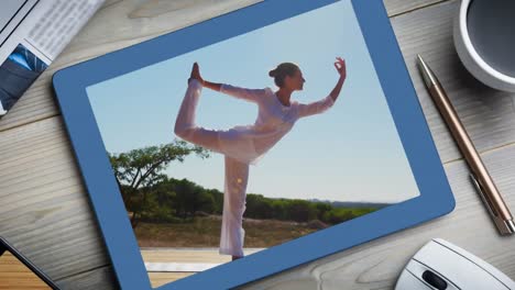 Animation-of-a-digital-tablet-showing-woman-practising-yoga-on-the-screen.
