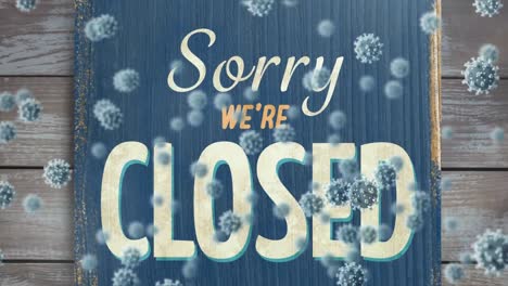 Animation-of-macro-Covid-19-cells-floating-over-a-sign-saying-Sorry-Were-Closed