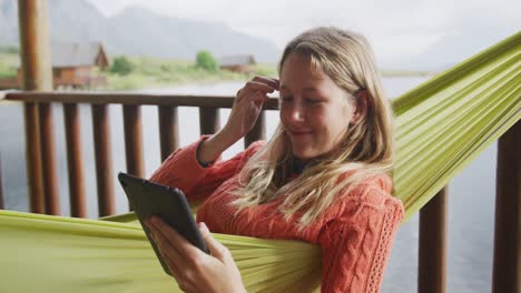 Caucasian-woman-having-a-good-time-on-a-trip-to-the-mountains,-using-a-tablet-and-smiling