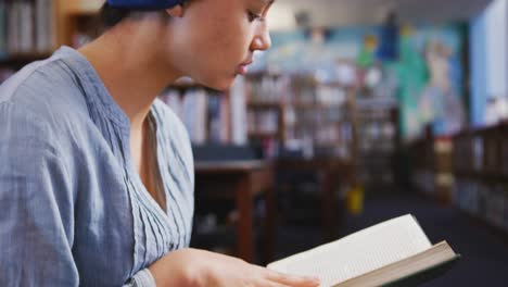 Asiatische-Studentin,-Die-Einen-Blauen-Hijab-Trägt,-Sitzt-Und-Liest-Ein-Buch