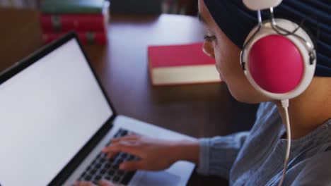 Estudiante-Asiática-Con-Un-Hijab-Azul-Sentada-Y-Escuchando-Música-En-La-Biblioteca