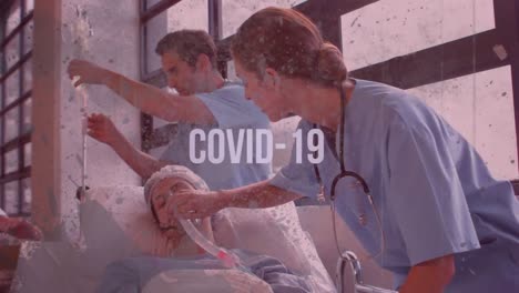 Animation-Eines-Worts-„Covid-19“,-Das-über-Ärzten-Blinkt,-Die-Mit-Einem-Bett-Gehen,-Auf-Dem-Sich-Ein-Patient-Befindet
