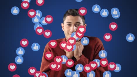 Mixed-race-man-over-heart-and-like-icon-floating-on-blue-background