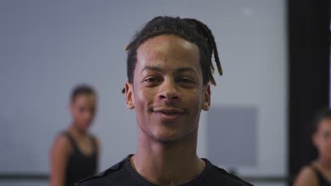 Portrait-of-a-mixed-race-modern-male-dancer-looking-at-the-camera-