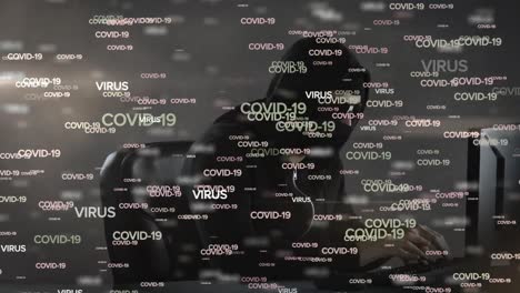Animation-of-COVID-19-and-VIRUS-words-over-a-hacker-hooded-man-on-a-computer