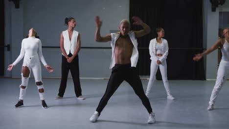 Mixed-race-modern-male-dancer-wearing-practicing-a-dance-routine-