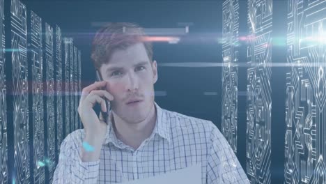 Animation-of-Caucasian-man-talking-on-his-smartphone-with-processing-servers-in-background