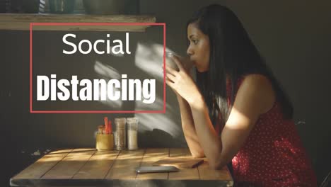 Animation-of-a-sign-SOCIAL-DISTANCING-over-Mixed-race-woman-taking-her-breakfast
