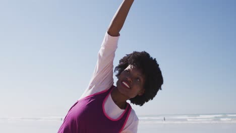 Mujer-Afroamericana-Haciendo-Posición-De-Pyoga-En-La-Playa-Y-Fondo-De-Cielo-Azul