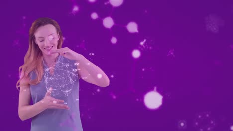 Animation-of-Caucasian-woman-presenting-a-globe-model-with-molecules-floating-on-purple-background