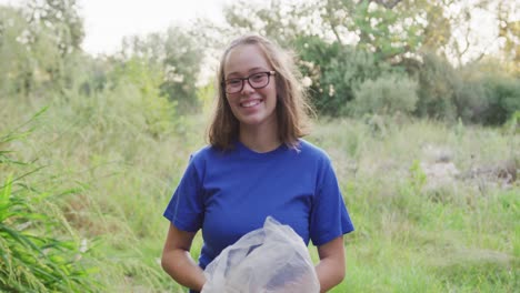 Caucasian-woman-smiling-and-looking-at-camera-during-river-clean-up-day