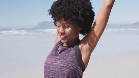 African-American-woman-stretching-out-on-the-beach-and-blue-sky-background