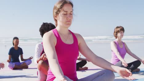Multiethnische-Gruppe-Von-Frauen,-Die-Yoga-Position-Am-Strand-Und-Im-Hintergrund-Des-Blauen-Himmels-Machen