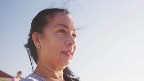 Mixed-race-woman-looking-at-the-view-on-the-beach-and-blue-sky-background