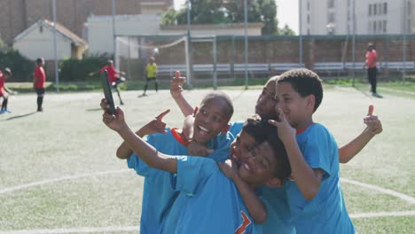 Niños-De-Fútbol-Vestidos-De-Azul-Tomándose-Una-Selfie-Y-Riendo-En-Un-Día-Soleado