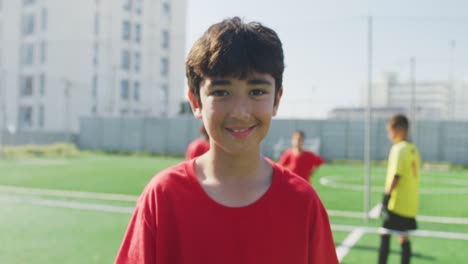 Niño-De-Fútbol-Caucásico-En-Rojo-Sonriendo-Y-Mirando-A-La-Cámara