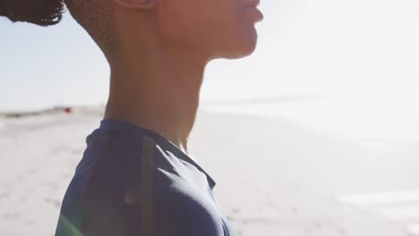 Afroamerikanische-Frau-Mit-Blauer-Sportmatte-Am-Strand-Und-Blauem-Himmel-Im-Hintergrund
