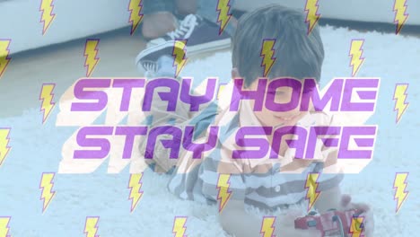 Animation-of-words-Stay-Home-Stay-Safe-with-lightning-icons-over-Caucasian-boy-playing-a-video-game