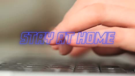Animation-Von-Blauen-Neonwörtern,-Die-Zu-Hause-Bleiben,-Während-Hände-Auf-Dem-Laptop-Tippen