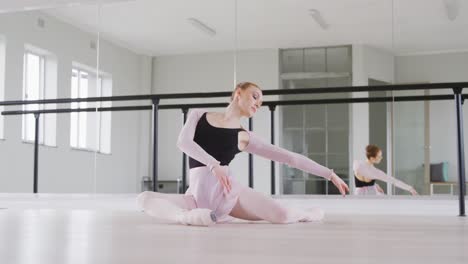 Kaukasische-Balletttänzerin,-Die-Sich-Auf-Dem-Boden-Ausstreckt-Und-Sich-Auf-Den-Tanzkurs-Vorbereitet