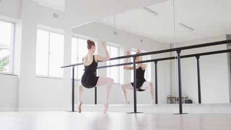 Kaukasische-Balletttänzerin,-Die-Sich-In-Einem-Hellen-Studio-Vor-Dem-Spiegel-Ausstreckt