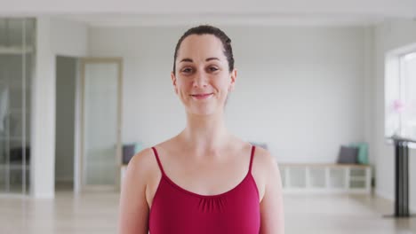 Caucasian-female-ballet-dancer-smiling-and-looking-at-camera