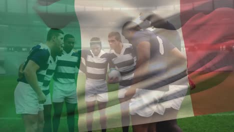 Animation-of-Italian-flag-waving-over-multi-ethnic-male-rugby-team-standing-in-a-huddle