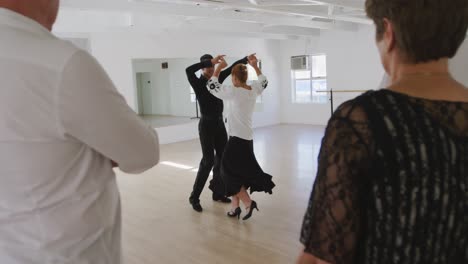 mixed-race-male-dance-teacher-taking-a-ballroom-dancing-class-at-a-dance-studio
