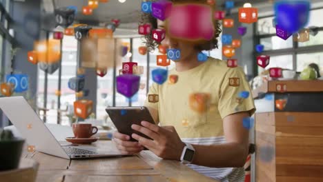 Animation-of-digital-cubes-icons-over-mixed-race-woman-sitting-in-a-cafe