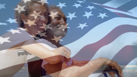 Mixed-race-couple-hugging-with-US-flag-waving-foreground